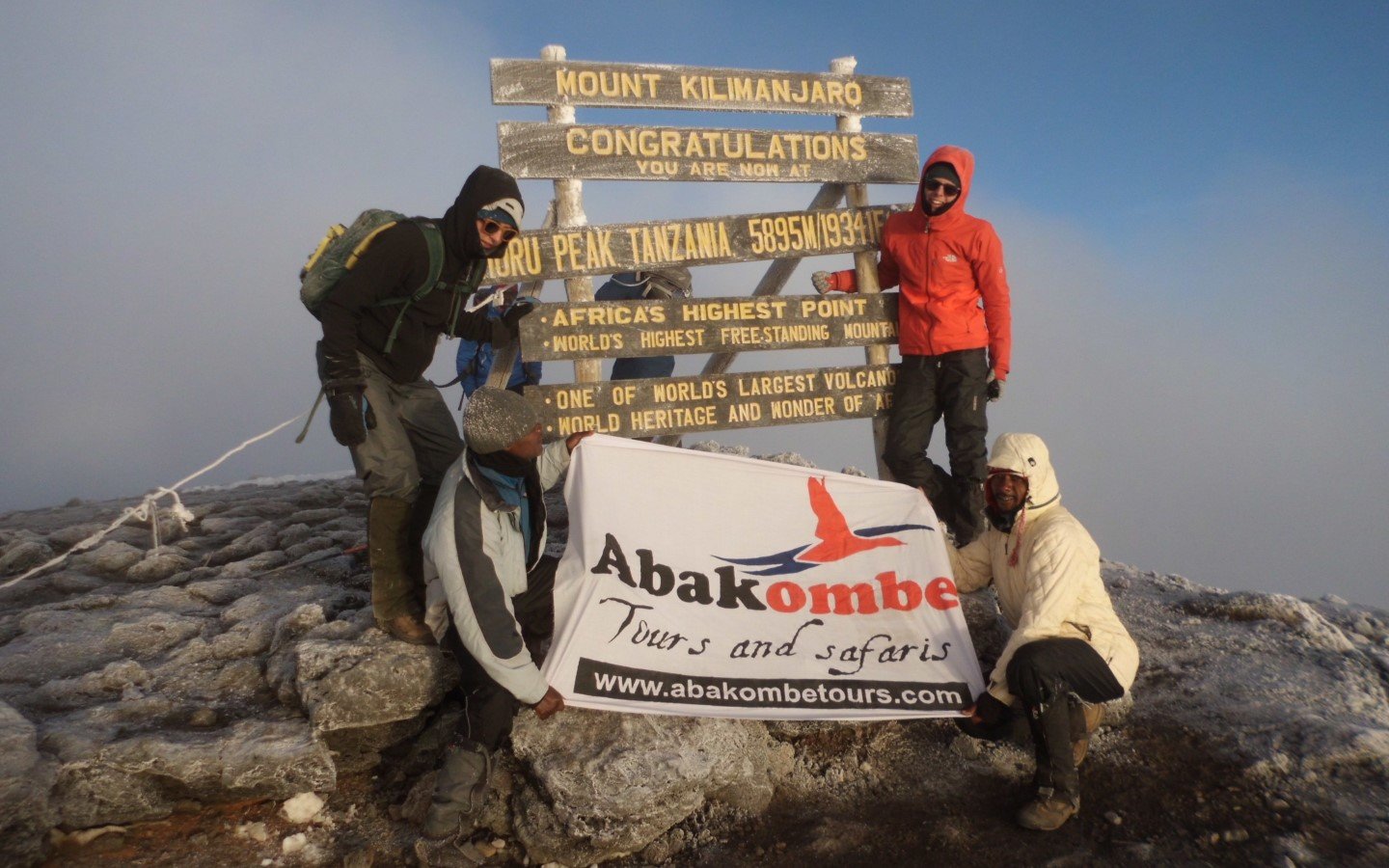 Climbers at the Kilimanjaro summit sign