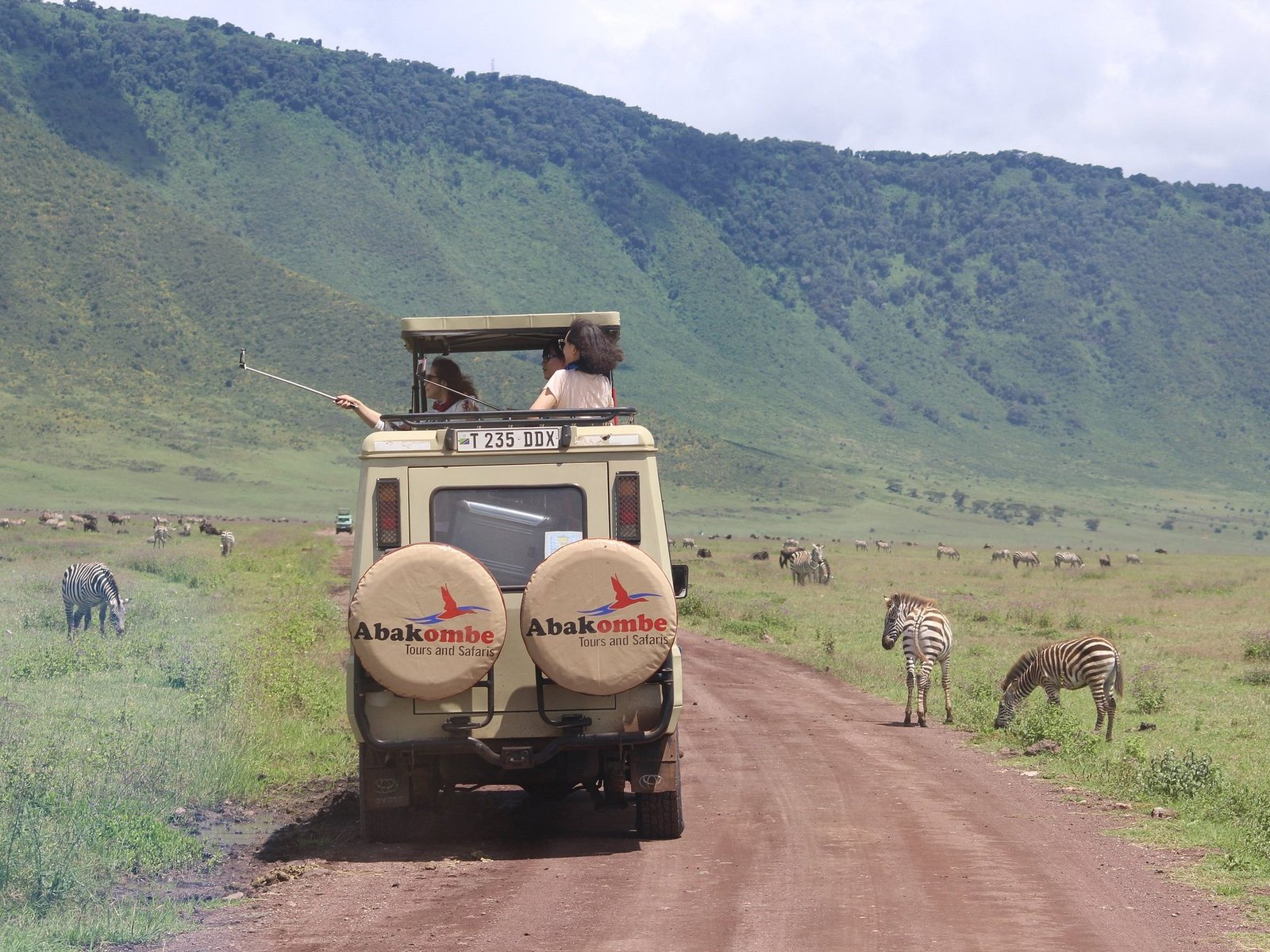 Abakombe safari vehicle with zebras in the Ngorongoro Crater